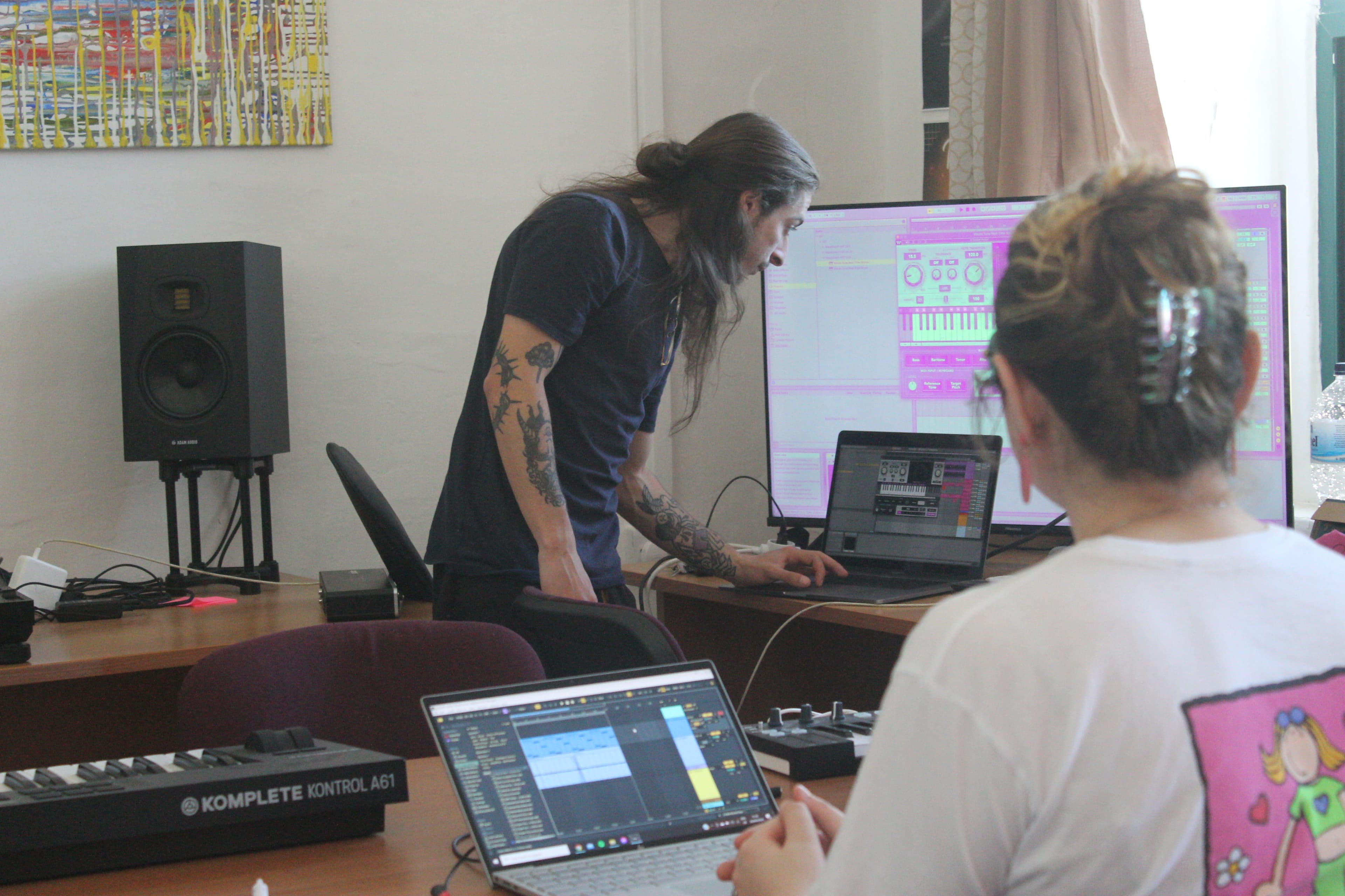 Students at laptops in a production workshop while an instructor demos a synth patch in Ableton Live on a large screen